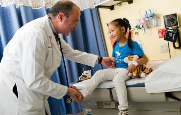 un médico examina a un niño con artrosis de cadera