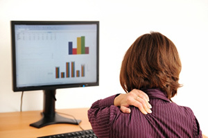 Osteocondrosis cervical en una mujer sentada frente a una computadora